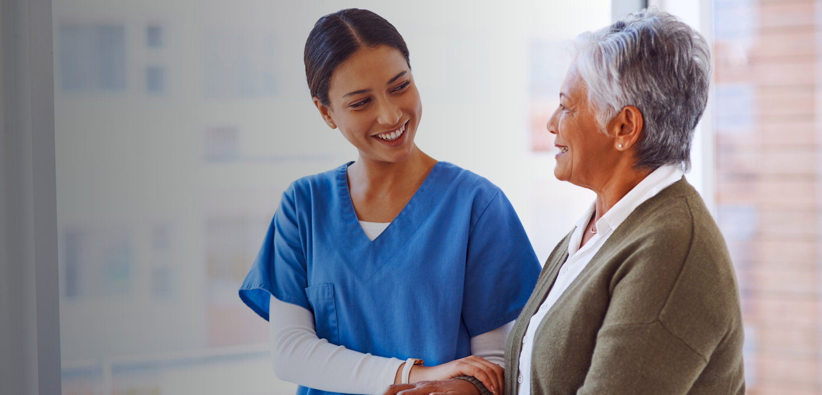 A nurse smilingly looking at the elderly