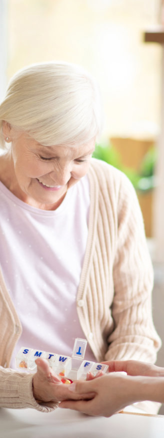 An elderly woman smiling while the nurse is looking at her