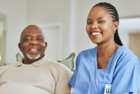 A nurse and an elderly man smiling