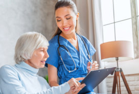 A nurse is looking at the elderly woman