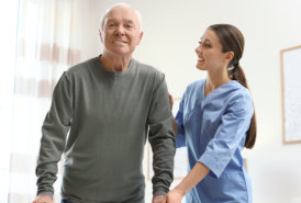 A nurse is looking to a smiling elderly man