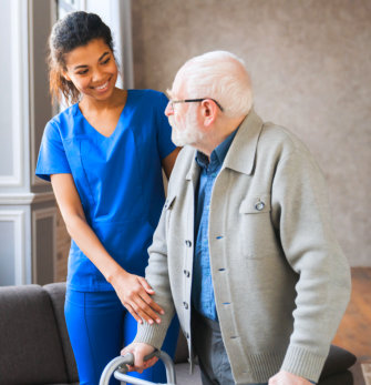 A nursing assisting an elderly man