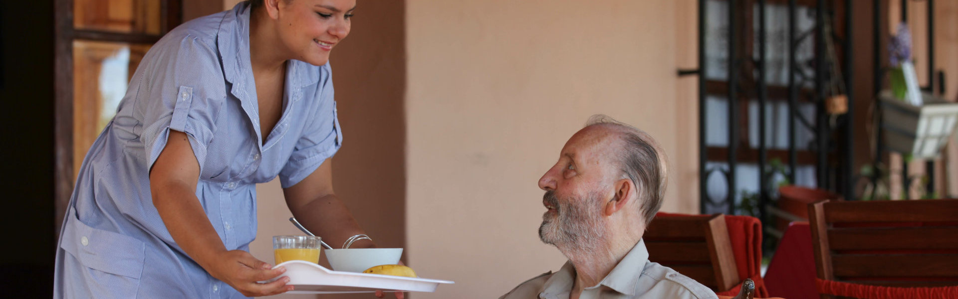 A woman giving food to an elderly man